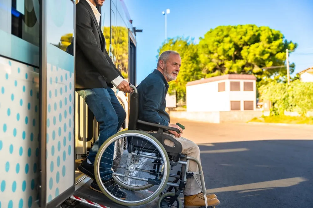 Rollstuhlfahrer wird aus dem Bus geholfen